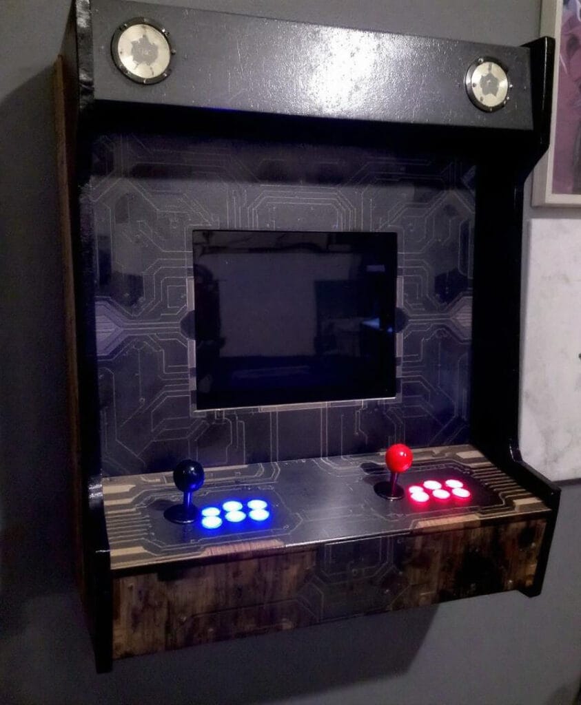 Wandmontierter Arcade-Spielautomat mit einem Bildschirm und zwei Steuerpulten in verschiedenen Farben.