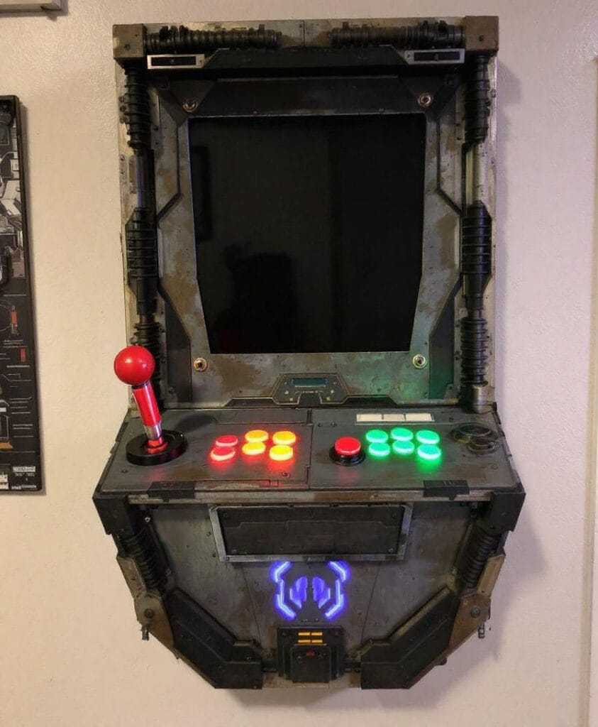 Wandmontierter Arcade-Spielautomat mit Joystick und bunten Tasten in einem industriellen Design.