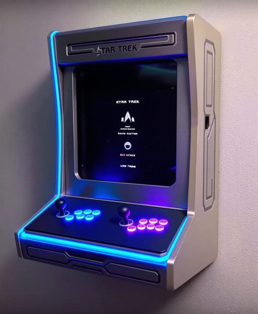 Wandmontierter Arcade-Spielautomat mit Star Trek-Thema und bunten Tasten.