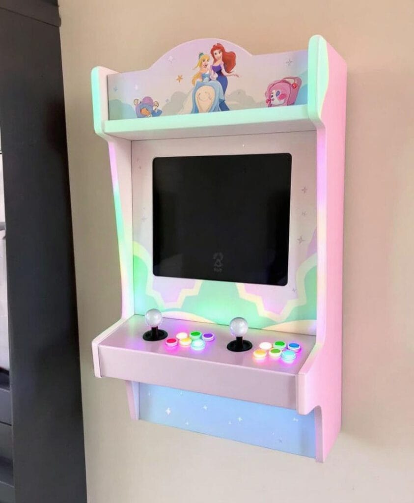 Wandmontierter Arcade-Spielautomat mit einem Bildschirm und bunten Tasten in pastellfarbenem Design.