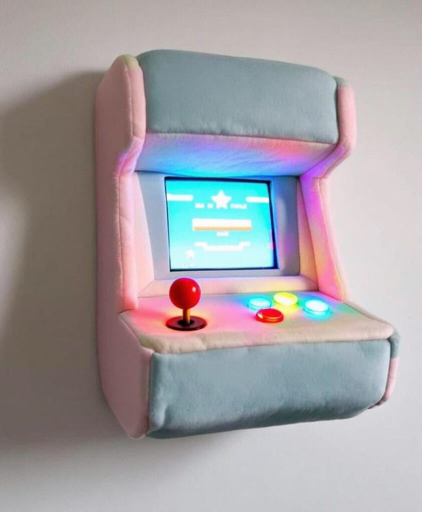 Wandmontierter Arcade-Spielautomat mit bunten Tasten und Bildschirm in sanften Farben.
