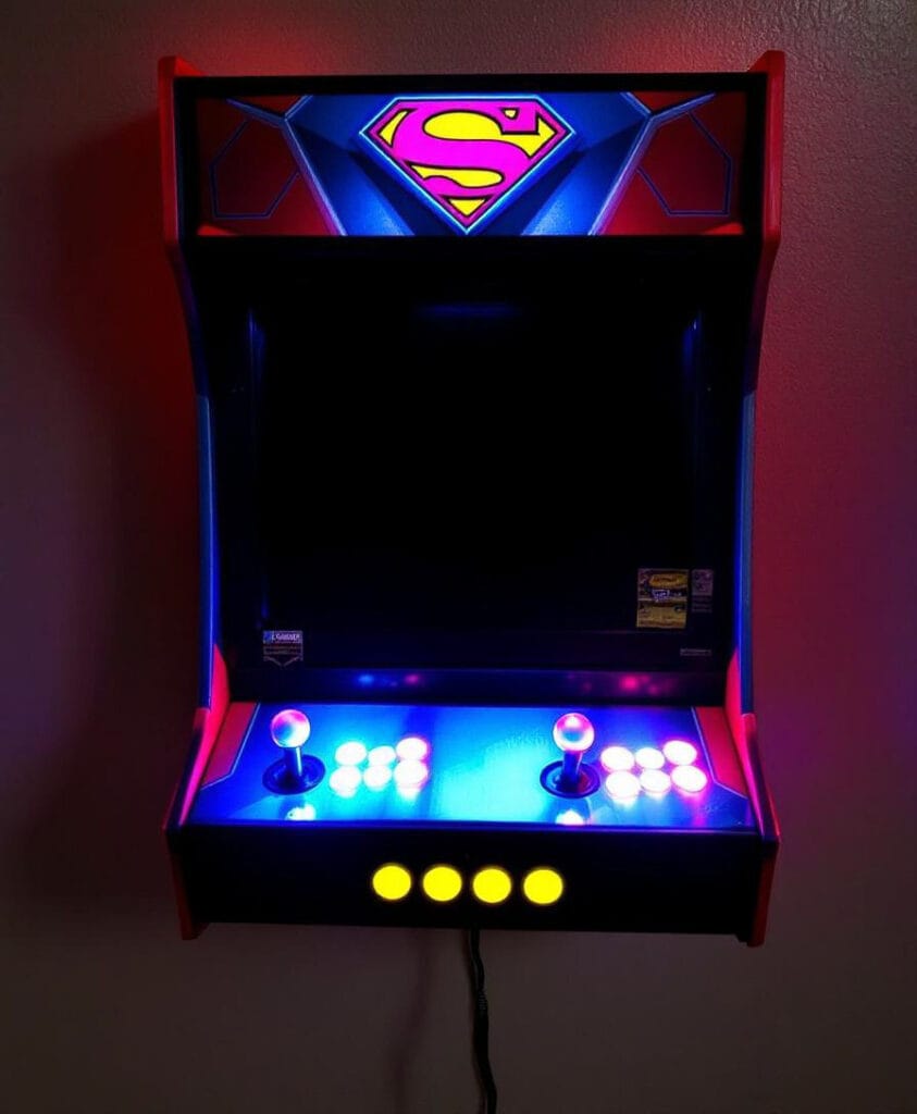 Wandmontierter Arcade-Spielautomat mit leuchtendem Superman-Logo und Steuerknöpfen.